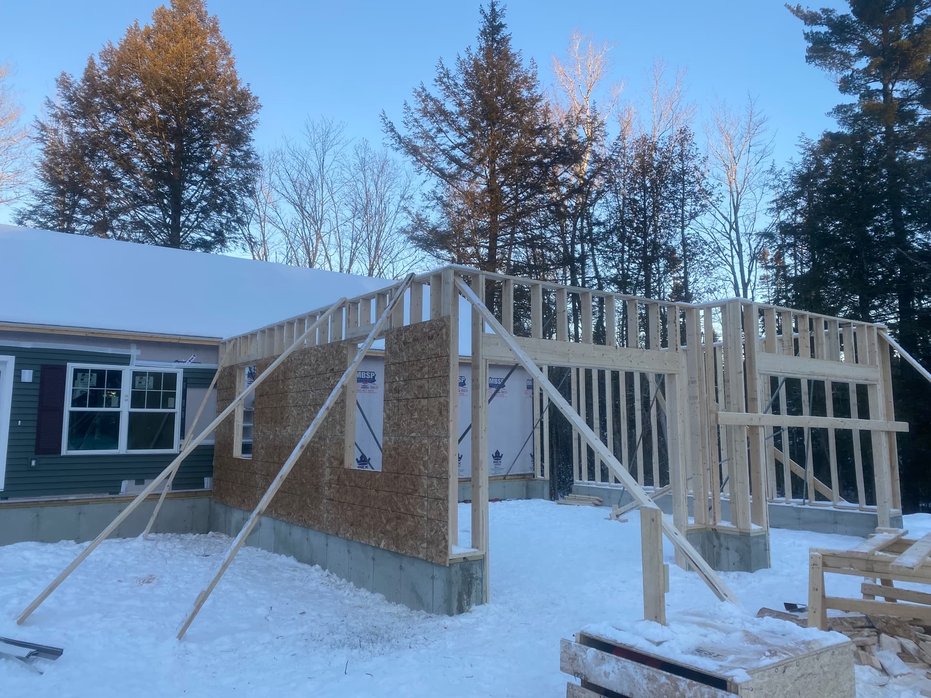 Wall framing for a winter home addition alongside a ranch house in Maine