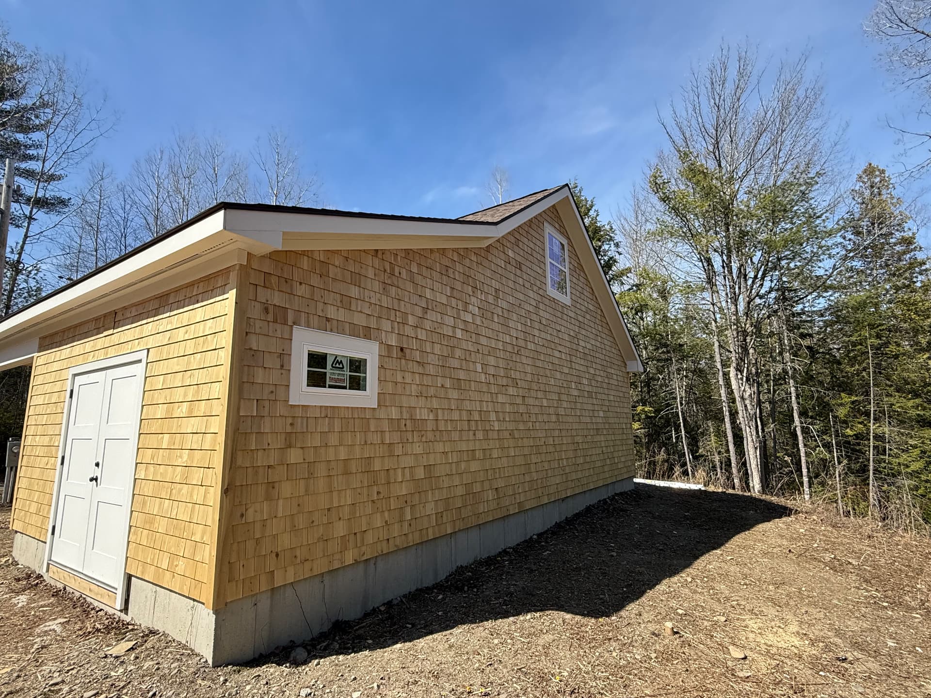 Side elevation of a finished cedar shingled garage with double entry doors