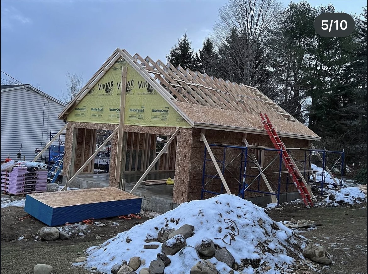 Roof rafters and sheathing going on the new garage during a Maine winter