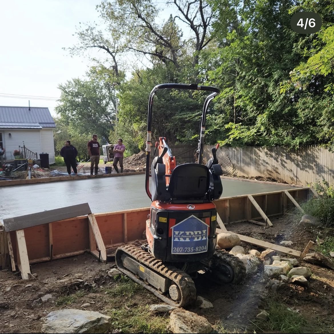 Keith Pomeroy Building mini excavator parked beside a finished concrete slab and forms