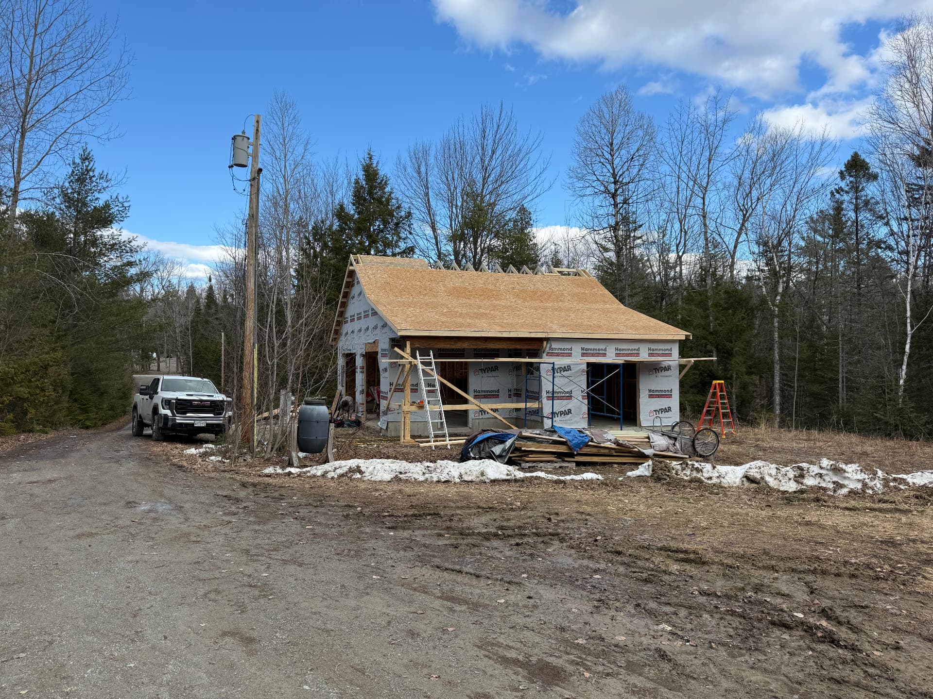 Detached garage with roof sheathing complete on a rural Maine property