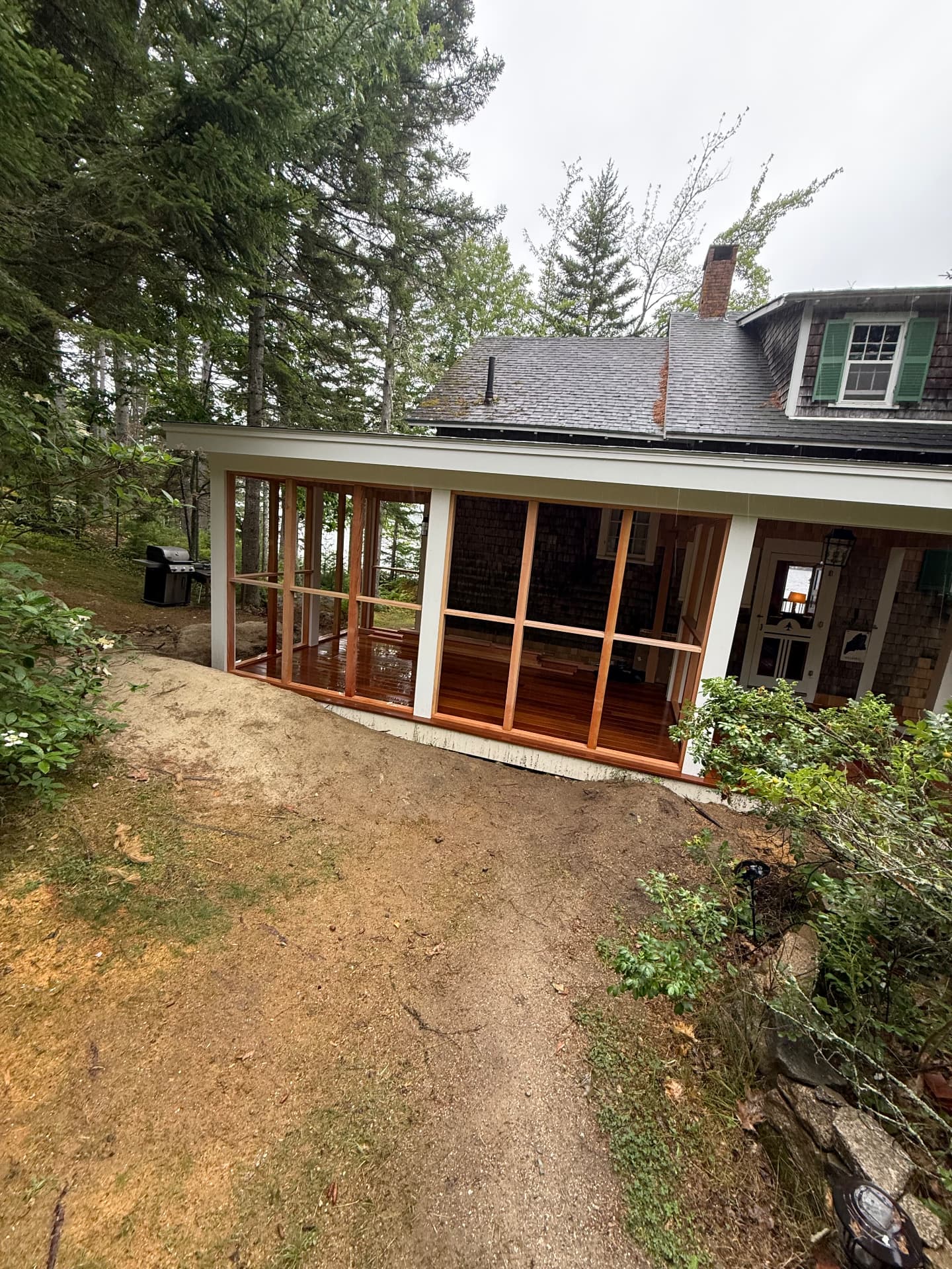 Screened porch addition with mahogany decking on a shingled Maine cottage