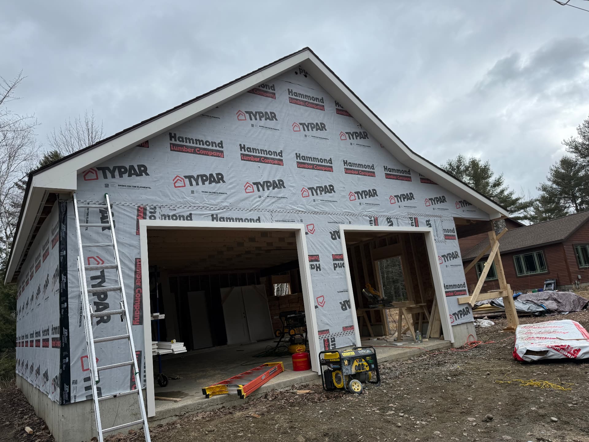 Weather-tight garage with shingled roof and framed overhead door openings