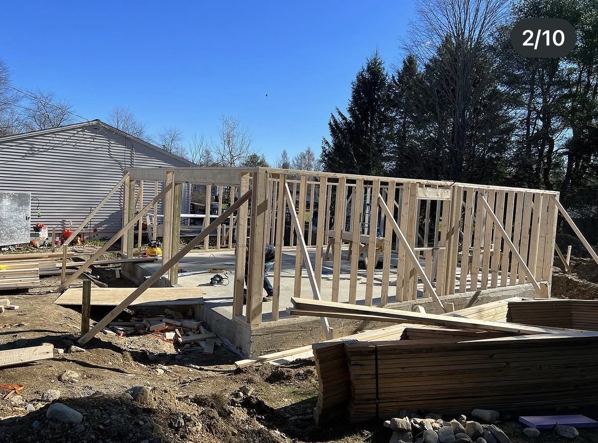 Wall framing standing on the new garage slab on a clear spring day