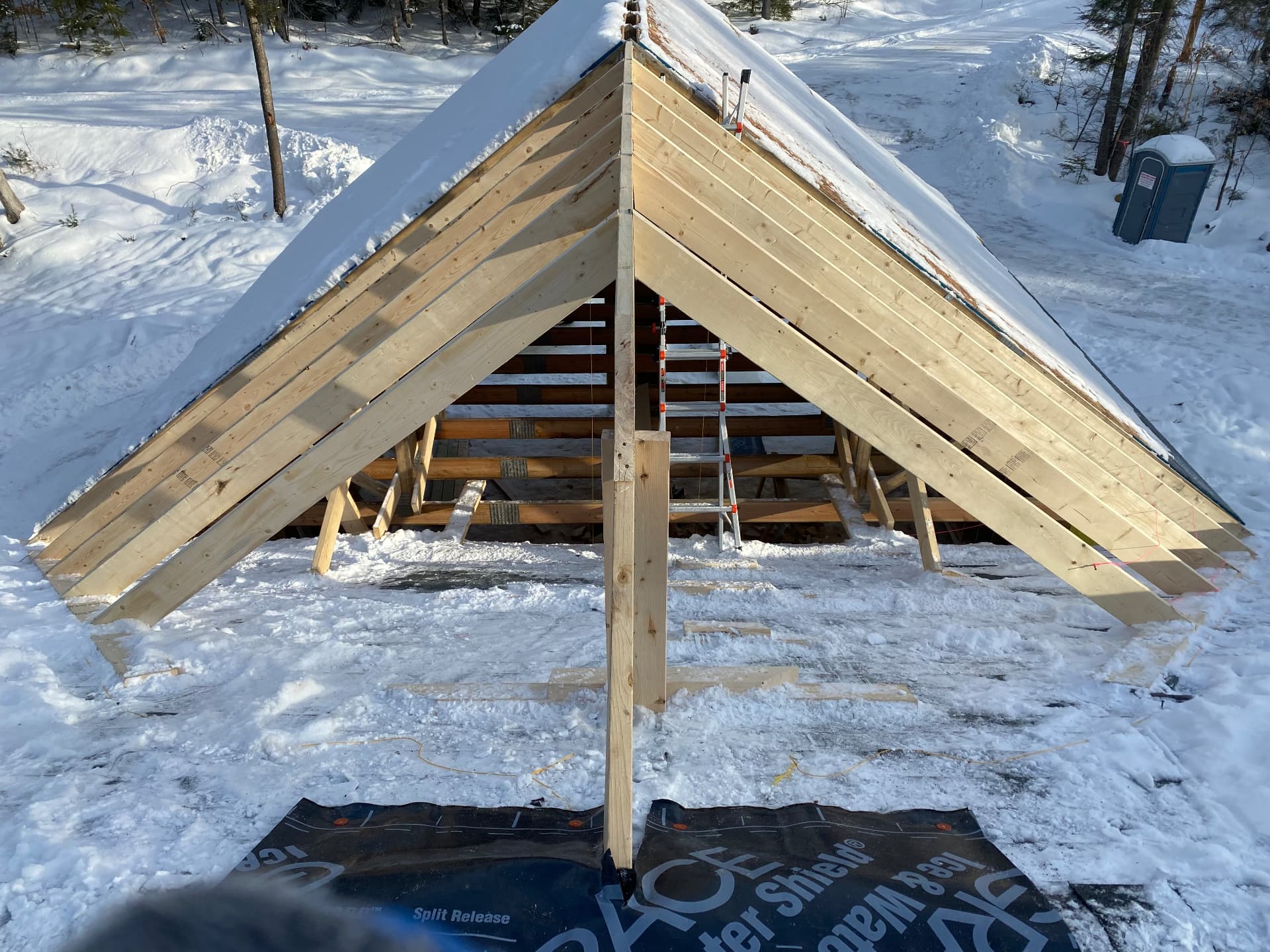 Roof rafters and ridge framing on a new addition in the snow