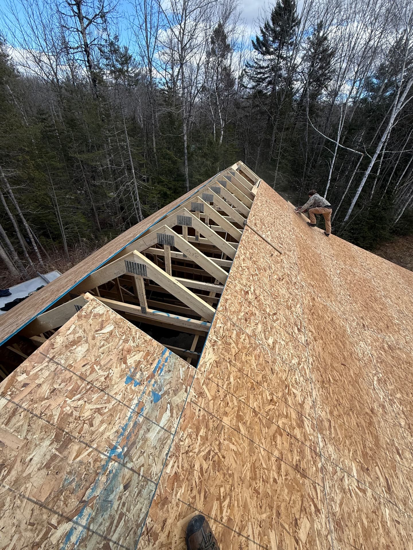Roof trusses and sheathing being installed on a new detached garage