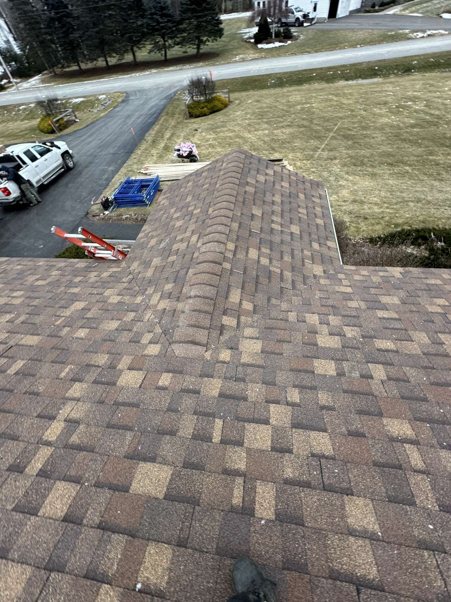 Newly installed architectural shingles on a hip roof section of a Maine home