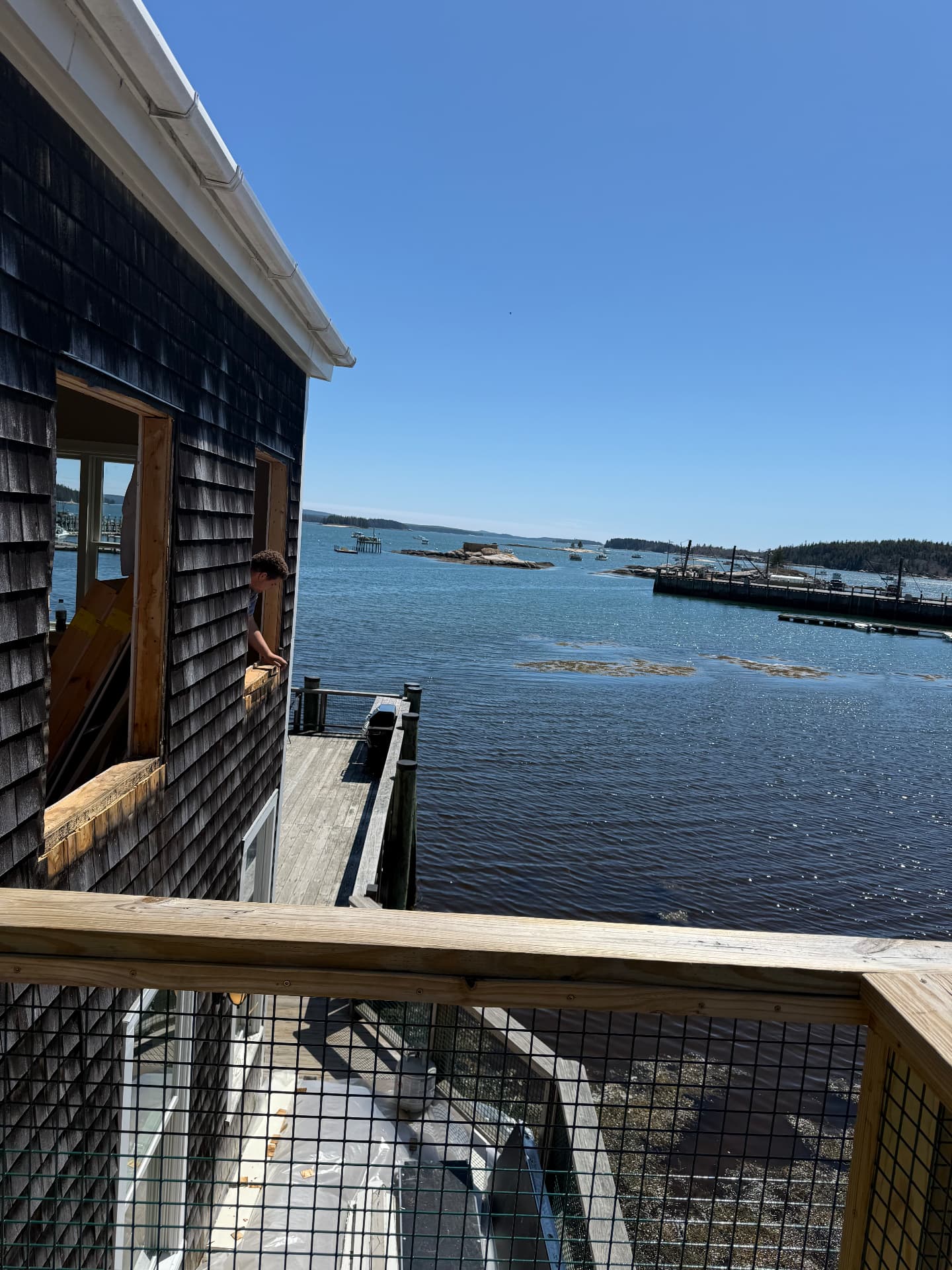 Waterfront window replacement on a shingled harborside building in Maine