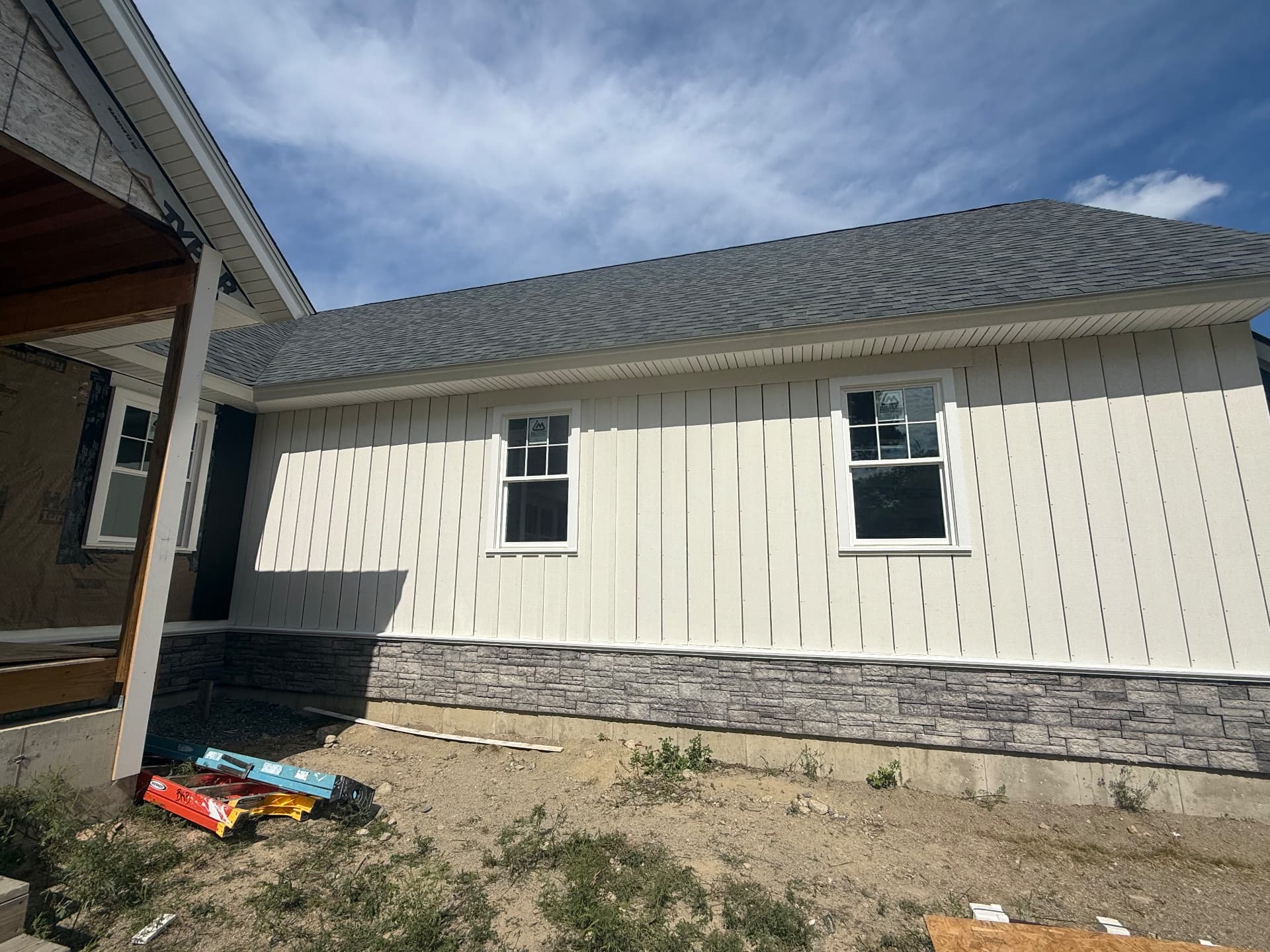 Board-and-batten siding and stone skirting on a finished ranch home exterior