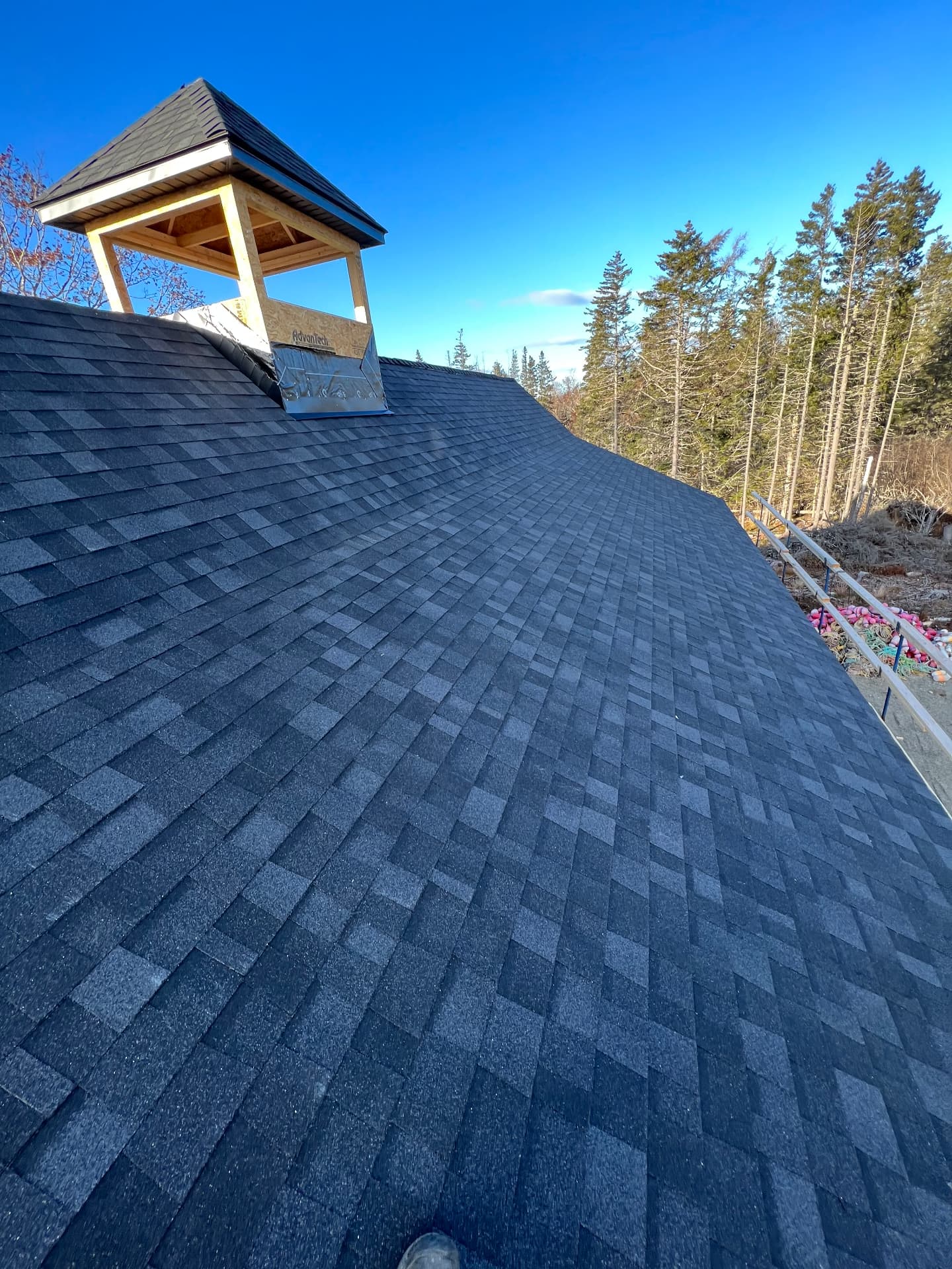 Finished architectural shingle roof with a cupola on a Maine home