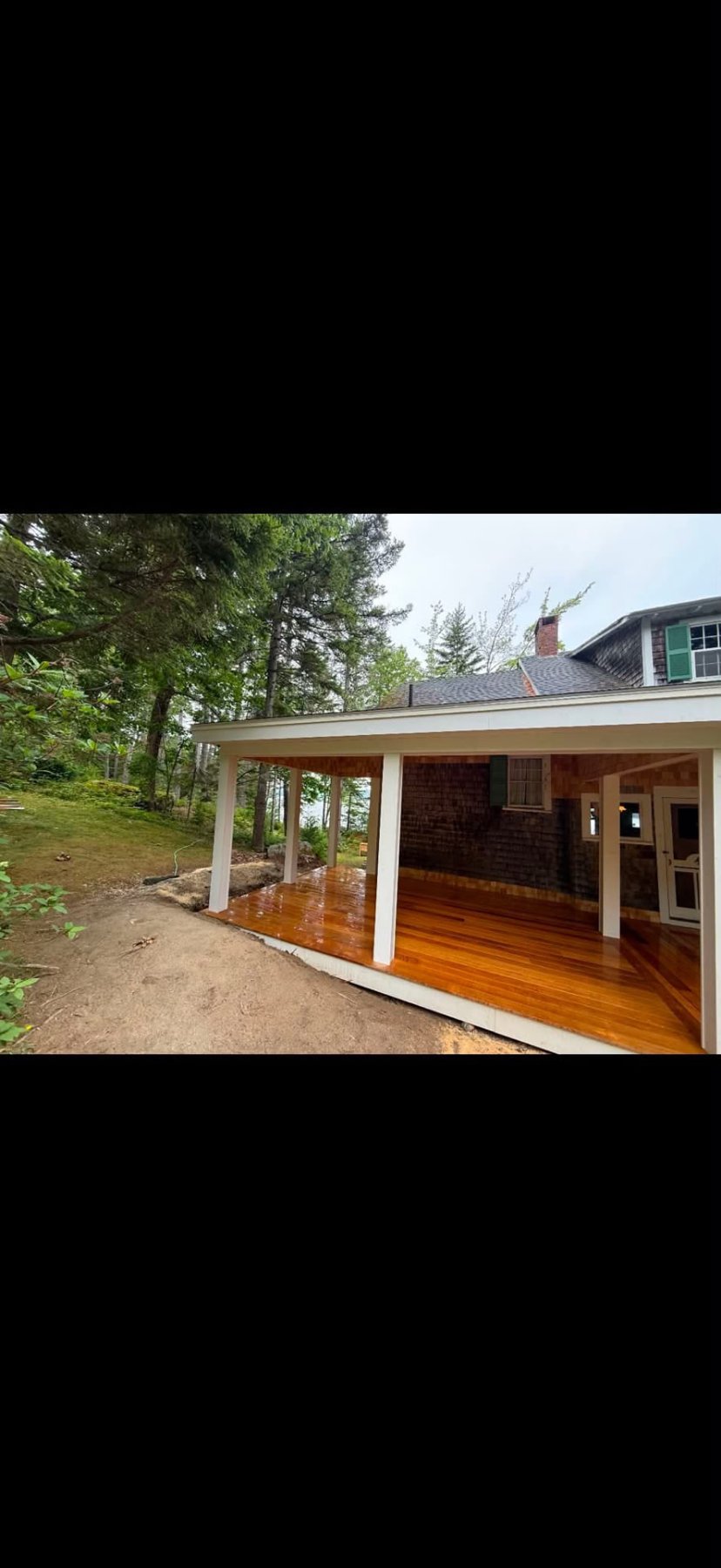 New covered porch with mahogany decking and white posts