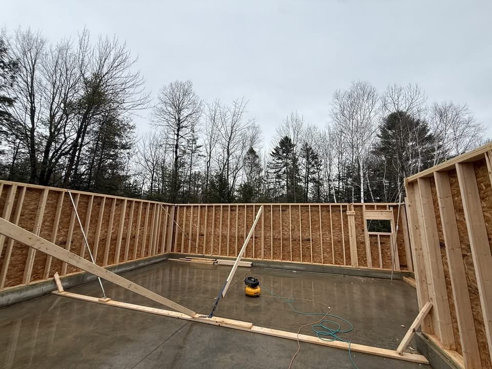 Wall framing on a new foundation slab during a Maine home build